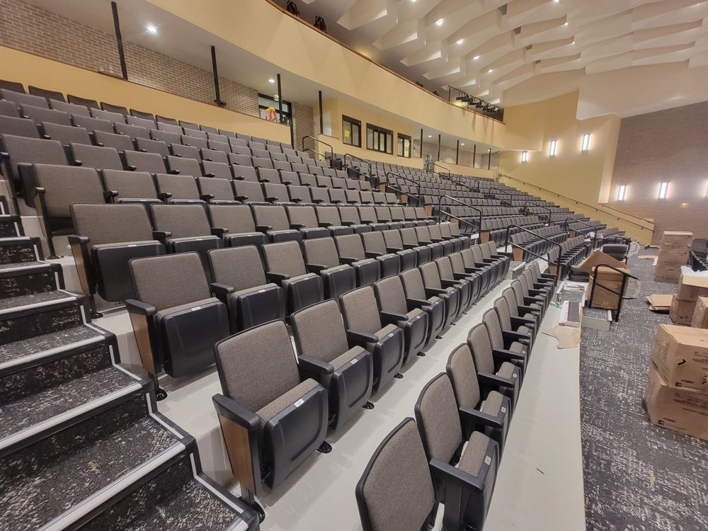 Charcoal auditorium seating seen from the aisle stairs