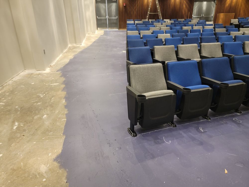 New blue and gray auditorium seats beside a fresh aisle