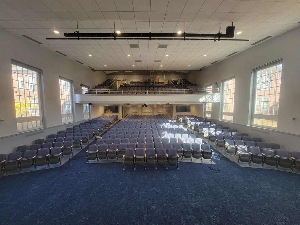Large auditorium with balcony and rows of new fixed seating