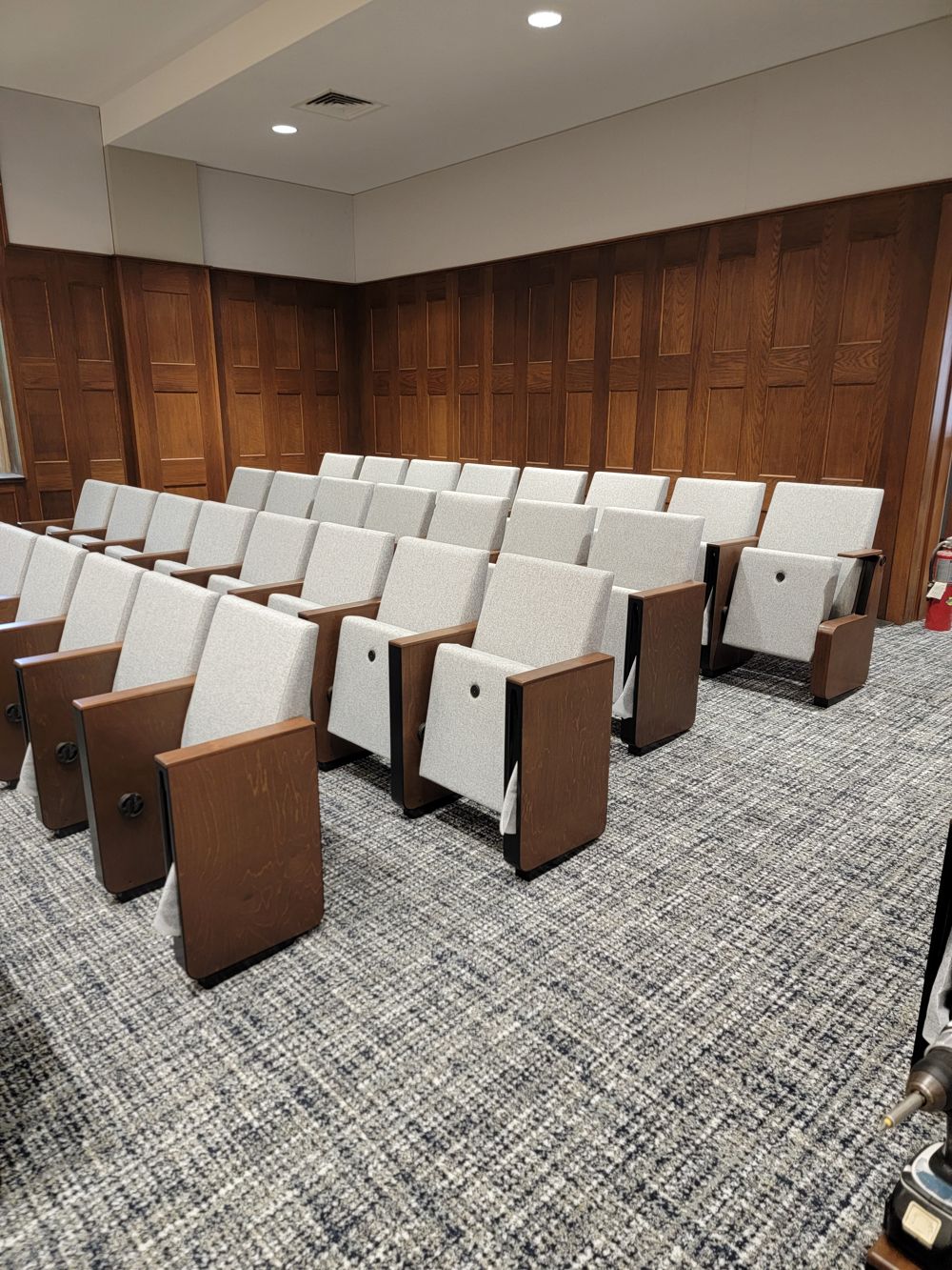 New white upholstered seats with wood end panels on patterned carpet